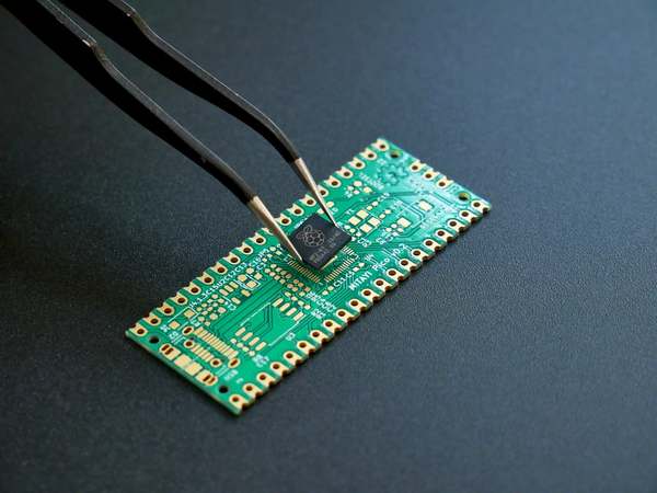 A chip placed on a circuit board with tweezers